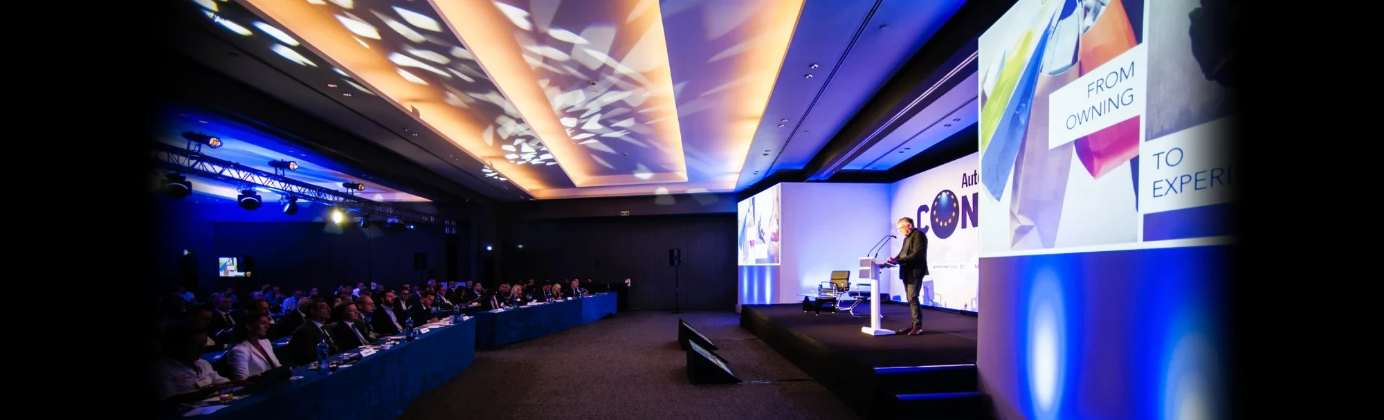 Gran reunión corporativa con iluminación profesional de escenario y audiencia.