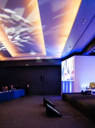 Gran reunión corporativa con iluminación profesional de escenario y audiencia.