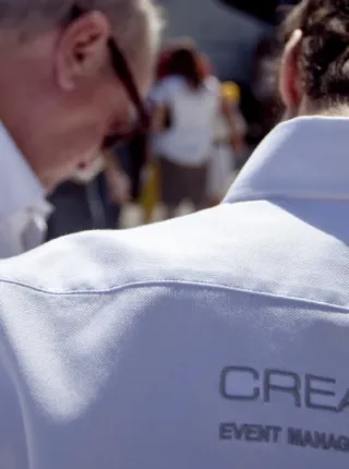 Primer plano del staff de CREA Group con uniforme durante un evento.