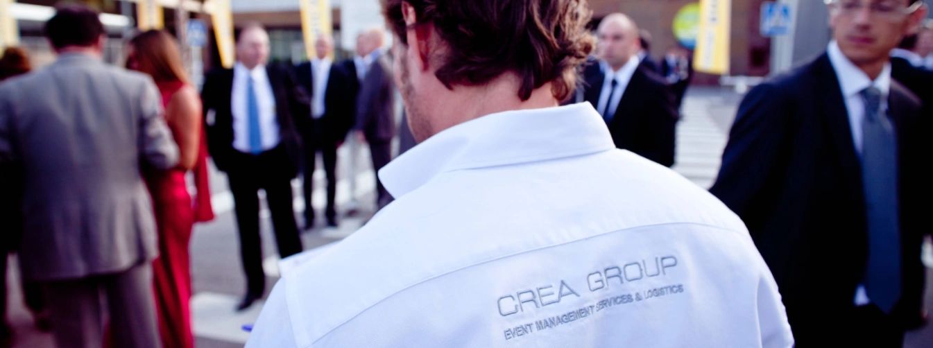 Wide shot of a sophisticated corporate event stage setup by Crea Group in Barcelona, featuring professional lighting rigs, large projection screens, and a seated audience, showcasing premium event management and production services.