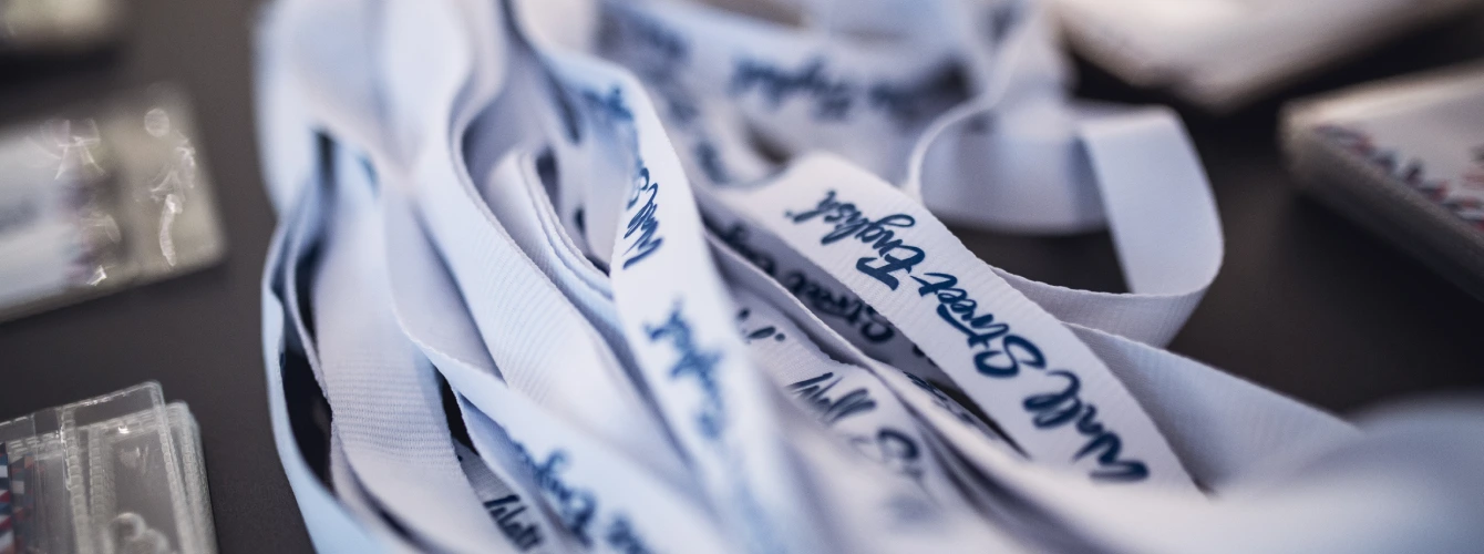 Wall Street English branded lanyards and name badges prepared for a language school conference or networking event