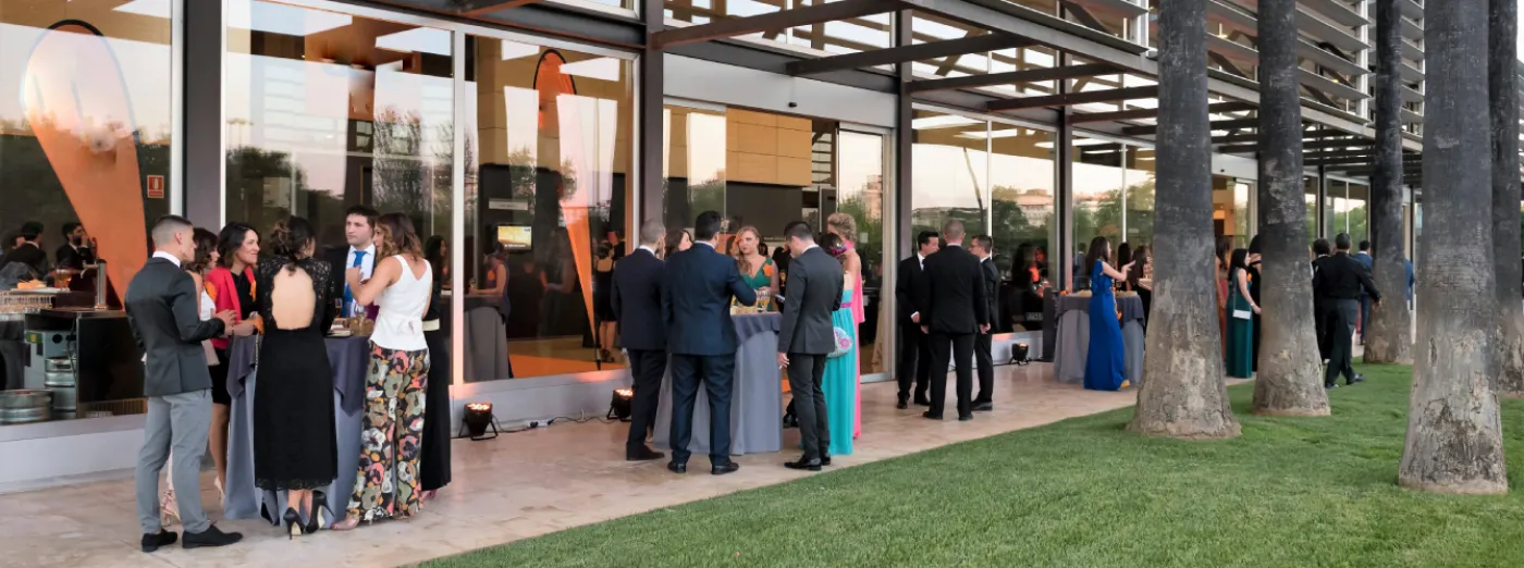 Professional networking cocktail reception at a modern outdoor event venue.