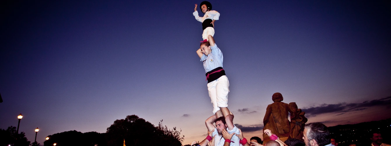 A traditional Catalan "Castellers" human tower performance during an evening outdoor corporate event.