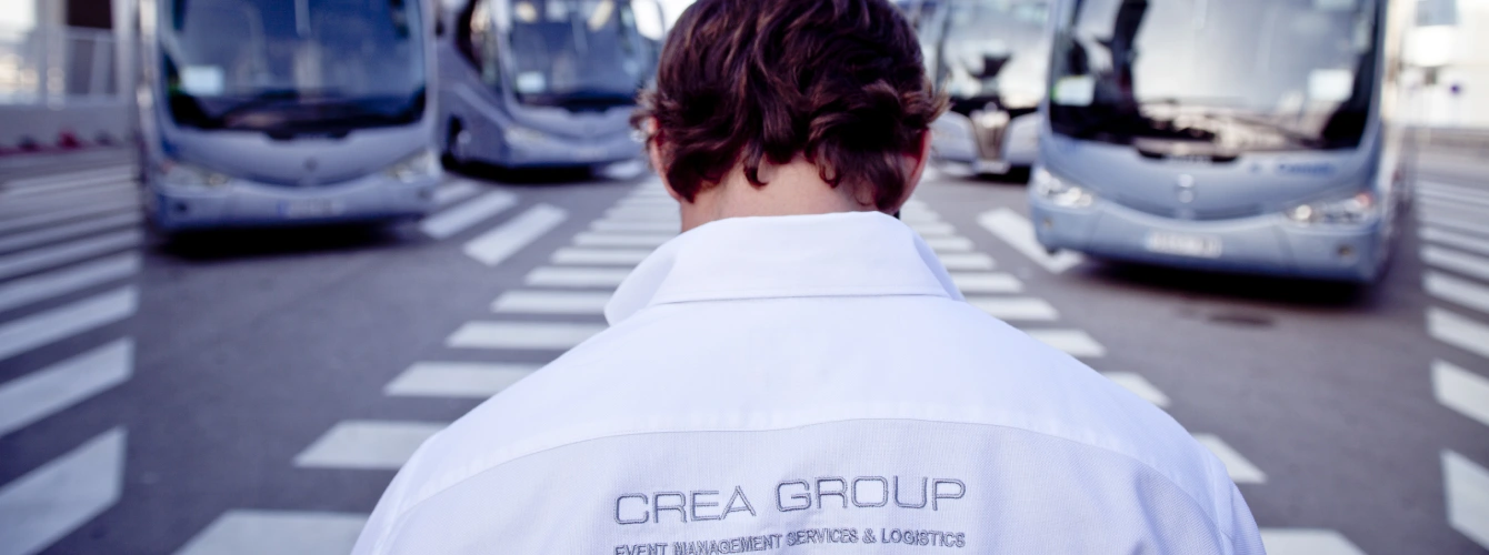 Close-up of the CREA Group logo and "Event Management Services & Logistics" branding on a professional staff polo shirt.