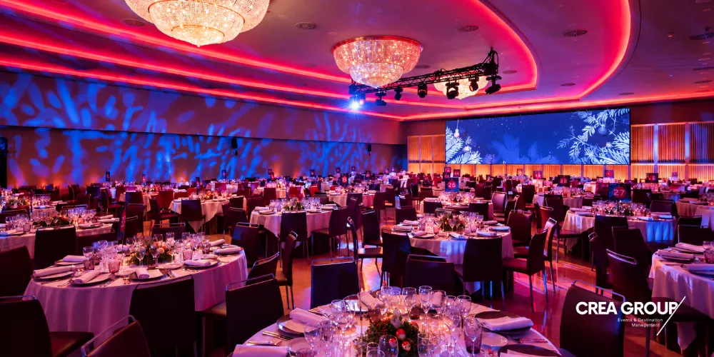 Vista de prop de les taules preparades i pantalles LED en una gala corporativa organitzada per al MWC Barcelona 2027.   