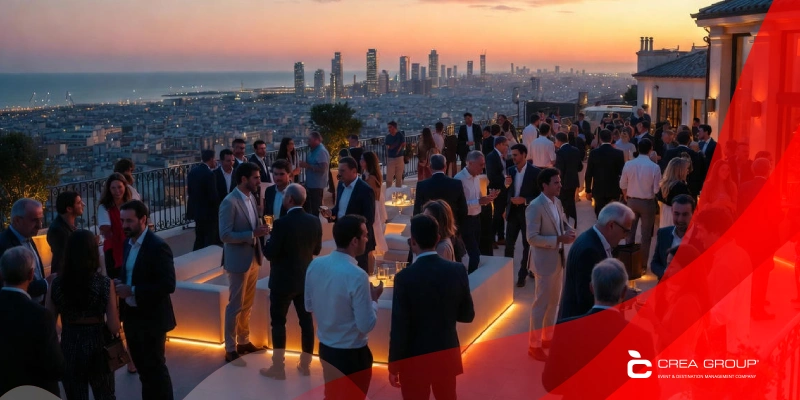 Corporate networking reception on Barcelona rooftop at sunset with panoramic city and sea views