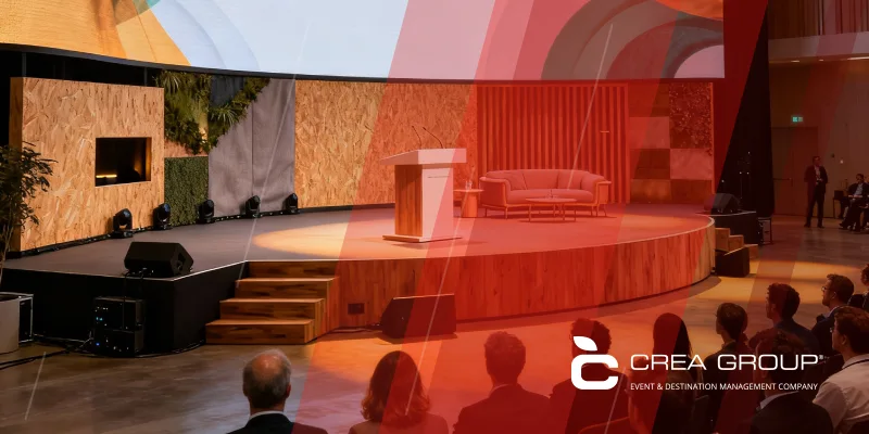 Auditorio moderno para eventos corporativos con escenario colorido, mobiliario elegante y excelente iluminación, ejemplo de diseño de interiores funcional y estético.