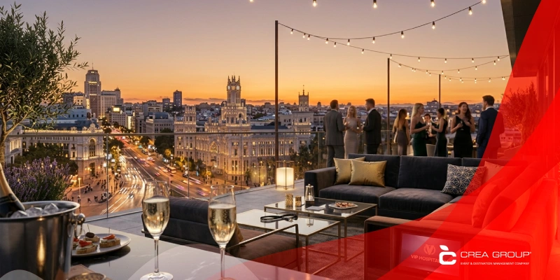 VIP hospitality service on a luxury rooftop terrace in Madrid at sunset, featuring elegant outdoor furniture, gourmet snacks, and glasses of champagne with a scenic city skyline view.